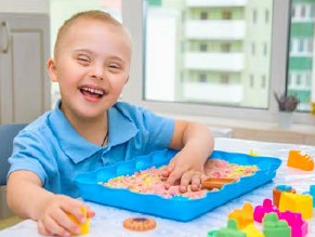 Child playing in table top sandpit